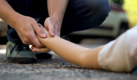 Someone holding the hand of an injured pedestrian