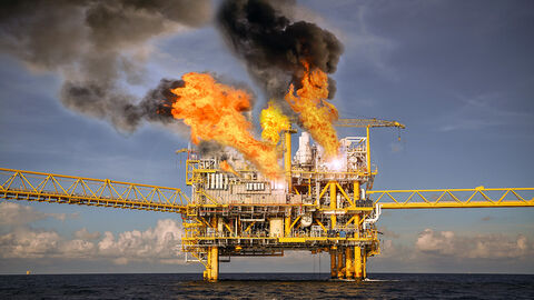 Oil rig on fire in the middle of the ocean
